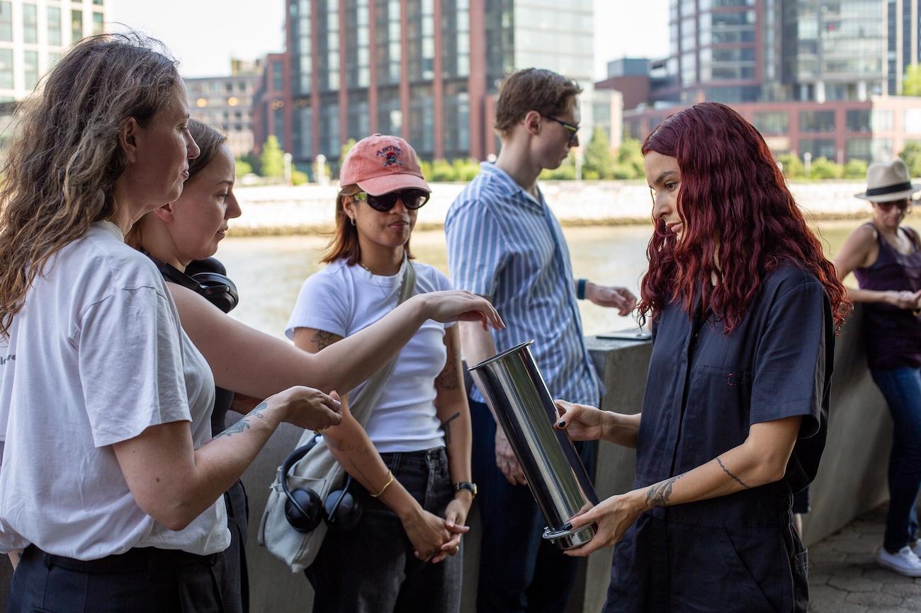 Carmen Baltzar collects seeds from audience members during their performance of “nothing to be seen here (a closed practice).” Photographed by Yann Chashanovski. Courtesy of Flux Factory.