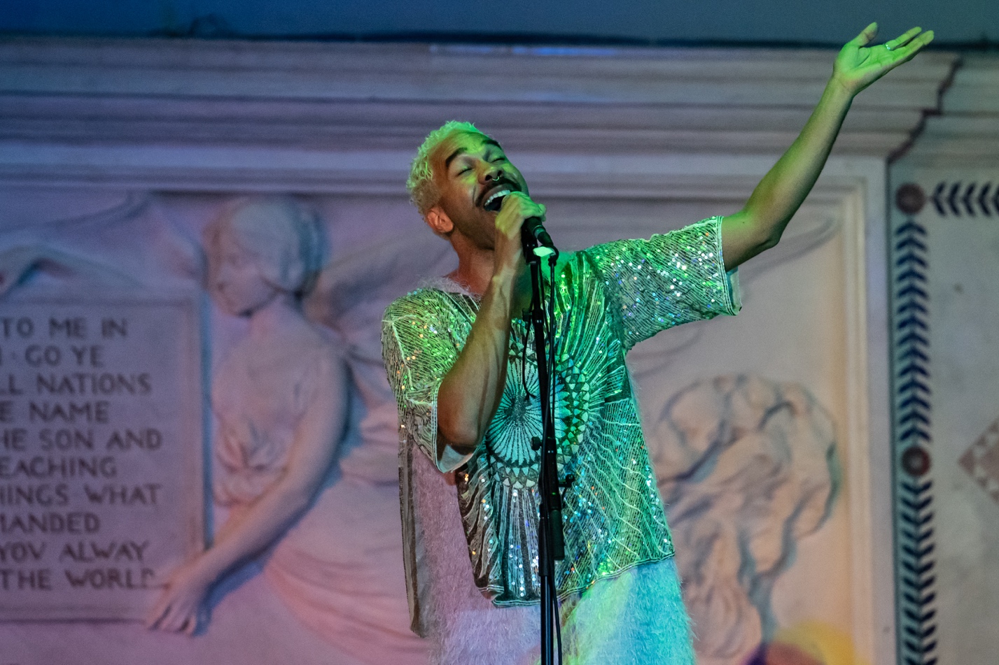 A person singing into a microphoneAI-generated content may be incorrect.